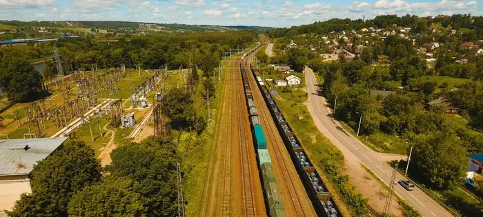 Luchtopname van een goederentrein op een spoorlijn door een groen landschap