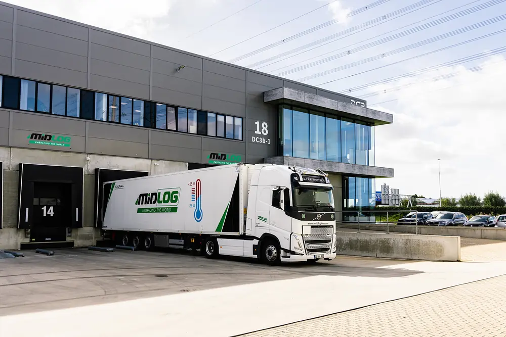 Vrachtwagen met trailer in Midlog-huisstijl aan het laaddock in Den Hoorn