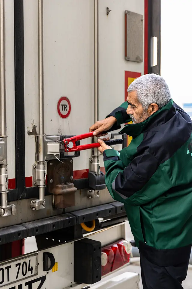 Medewerker beveiligt de achterdeuren van een trailer met een slot